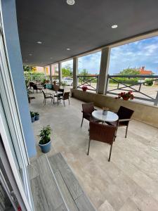 a patio with tables and chairs and windows at Iris Studios in Umag