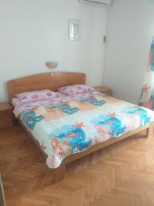 una camera da letto con un piumone colorato di Guest House Silvia a Rab