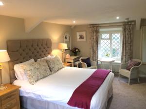 a bedroom with a large white bed with a purple blanket at The Old Forge in Totnes