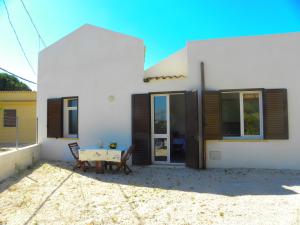 a white house with a table in front of it at Stagnone Kitesurf Paradise in Birgi Vecchi