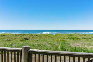 a wooden fence in front of a beach at Impressive Oceanfront Home in Westport