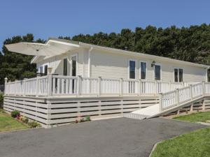 a mobile home with a porch and an umbrella at Jonstone Pines in Scarborough