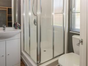 a bathroom with a shower and a toilet and a sink at Jonstone Pines in Scarborough +12 photos