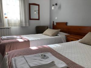 a hotel room with two beds and a television at Residencial Celeste in Águeda