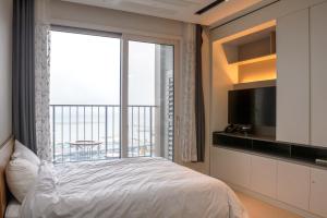 sypialnia z łóżkiem i dużym oknem w obiekcie Sokcho Daemyung Pension Samsung Home prestige w mieście Sokcho