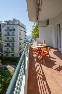 einen Balkon mit einem Tisch und Stühlen auf einem Gebäude in der Unterkunft le capitole in Nizza