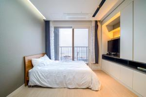 Sokcho Daemyung Pension Samsung Home prestige في سوكشو: غرفة نوم بسرير ونافذة كبيرة