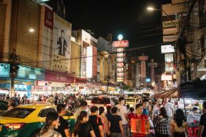 a crowd of people on a busy city street at night at Lhong Yaowarat hostel in Bangkok