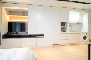 uma cozinha branca com armários brancos e um micro-ondas em Sokcho Daemyung Pension Samsung Home prestige em Sokcho