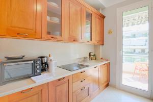 a kitchen with wooden cabinets and a microwave at le capitole in Nice