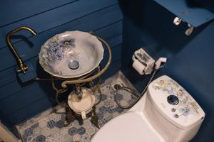 La salle de bains bleue est pourvue d'un lavabo et de toilettes. dans l'établissement Lhong Yaowarat hostel, à Bangkok