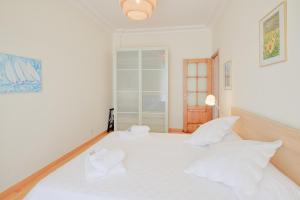 a bedroom with a white bed with white pillows at le capitole in Nice