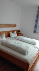 Una cama con dos almohadas blancas encima. en Hotel Restaurant Hirsch, en Schmiechen