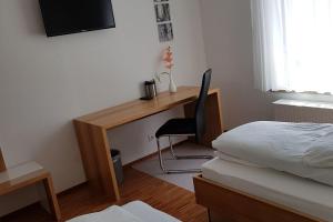 um quarto com uma secretária, uma cama e uma cadeira em Hotel Restaurant Hirsch em Schmiechen