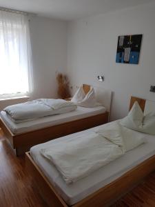 two twin beds in a room with a window at Hotel Restaurant Hirsch in Schmiechen