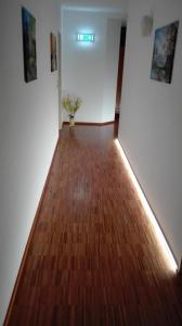 a hallway with a hard wood floor and a plant at Hotel Restaurant Hirsch in Schmiechen