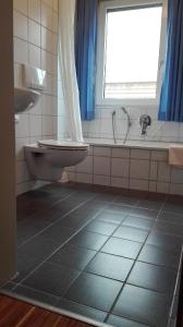 a bathroom with a toilet and a tub and a window at Hotel Restaurant Hirsch in Schmiechen