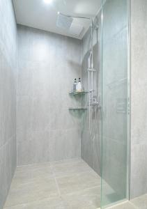 a bathroom with a shower with a glass door at Sokcho Daemyung Pension Samsung Home prestige in Sokcho