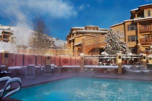 Sundial Lodge by All Seasons Resort Lodging في بارك سيتي: مسبح مع شجرة عيد الميلاد ومباني