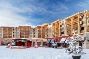 un gran edificio de apartamentos con nieve en el suelo en Sundial Lodge by All Seasons Resort Lodging, en Park City