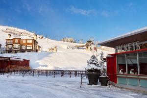 einen schneebedeckten Berg mit einem Gebäude und einer Skipiste in der Unterkunft Sundial Lodge by All Seasons Resort Lodging in Park City