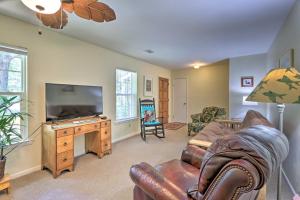 a living room with a couch and a flat screen tv at Downtown Home with Yard and BBQ - 6 Mi to Downtown! in Beaufort