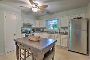 a kitchen with a stainless steel refrigerator and a table at Downtown Home with Yard and BBQ - 6 Mi to Downtown! in Beaufort