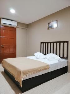 a bedroom with a bed and a red door at Hotel Nawar in Pasir Mas