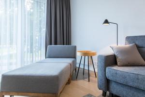 een woonkamer met een bank en een stoel bij Apartment Hotel Laisve in Druskininkai
