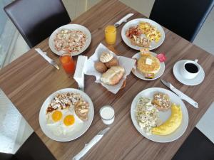 a wooden table topped with plates of breakfast food at Hotel Campestre Inn in León