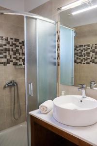 a bathroom with a sink and a shower at Sirines Apartments in Palekastron