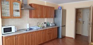 a kitchen with wooden cabinets and a stainless steel refrigerator at Pokoje nad rzeką in Kudowa-Zdrój