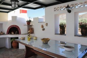 a dining room with a table and a fireplace at Sirines Apartments in Palekastron