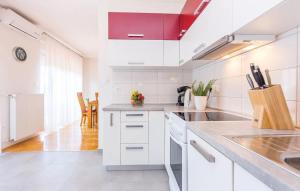 a white kitchen with white cabinets and a sink at Big White apartment in Novi Vinodolski