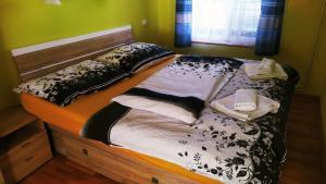 a bed with black and white sheets and pillows at Apartmány v Centru in Třeboň