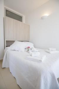 a white bed with two towels and a flower on it at Lovely apartment near the sea 25 bis Promenade des Anglais in Nice