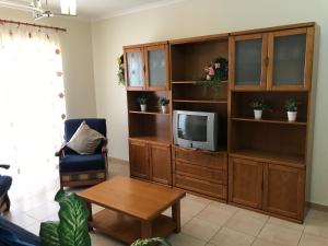 a living room with a entertainment center with a tv at Villa BelaVista with Private Pool in Ferragudo