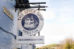 un panneau pour la restauration du navire magere sur le côté d'un bâtiment dans l'établissement The Spice Ship, à Weymouth