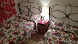 1 dormitorio con 2 camas y mesa con lámpara en Casa Rural Aventura I, en Navaluenga