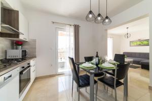 a kitchen and dining room with a table and chairs at Villa Sun Garden - 4 star villa with heated swimming pool, quiet bay, BBQ, 50m from the sea in Milna