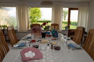 - une table à manger avec une nappe blanche et des œufs dans l'établissement Shalom, à Gjerlev