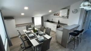 ein Esszimmer und eine Küche mit einem Tisch und Stühlen in der Unterkunft Guesthouse Villa Brestova in Plomin