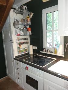 a kitchen with a stove top oven next to a window at Gästehaus "Villa am Eggenbach" Familie Heiss in Eggenbach