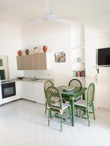 une cuisine avec une table et des chaises vertes dans l'établissement Residenza l 'Ulivo, à Parghelia