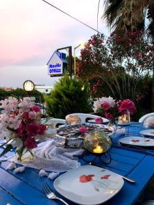 uma mesa azul com pratos e flores em Maviev Otel em Cesme