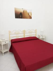 a bedroom with a large red bed with two tables at Dimora l 'Ulivo in Parghelia