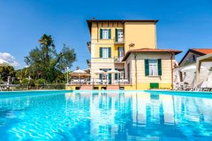 a large swimming pool in front of a house at Hotel Maderno by Double Hospitality in Toscolano Maderno