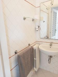 a white bathroom with a sink and a mirror at Dimora l 'Ulivo in Parghelia +15 photos