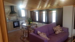 sala de estar con sofá púrpura y mesa en Apartamentos Plan Dulcis, en Buera