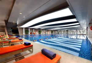 a large swimming pool with orange and blue cushioned chairs at Howard Johnson Hi - Tech Plaza Chengdu in Chengdu